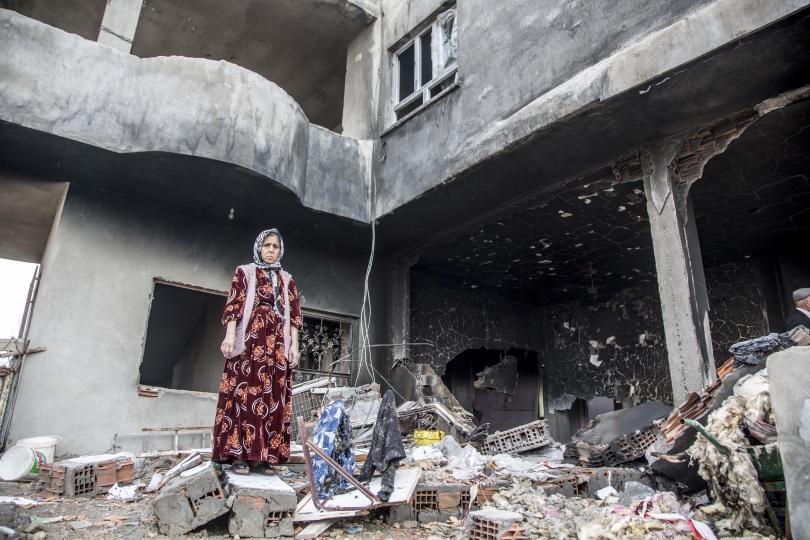 woman standing in wreckage of building